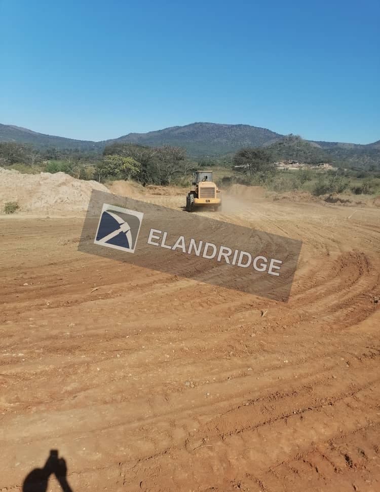 Front-end loader working the heap leach pad