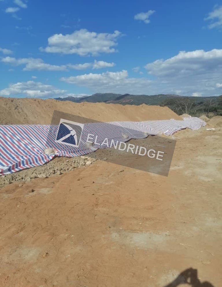 Geomembrane weighted with sandbags on a pad embankment